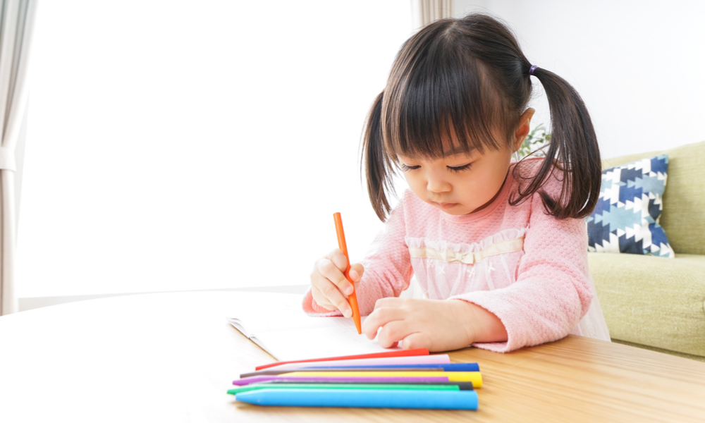 Child drawing with crayons