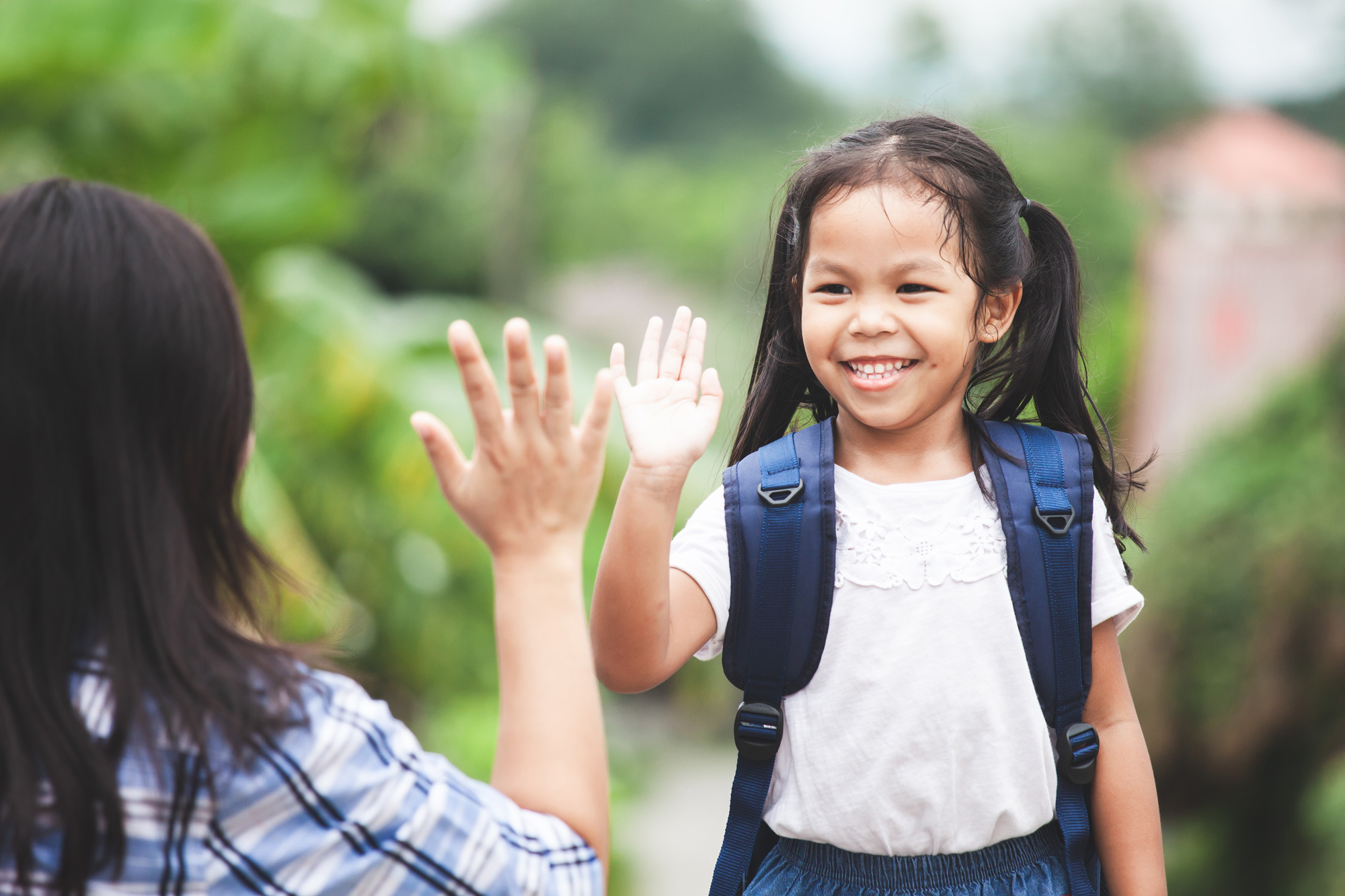 Young girl giving adult a high five