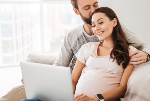 Pregnant couple researching childcare online