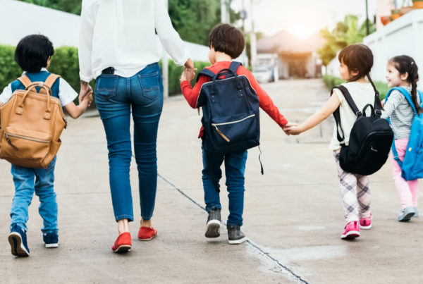 Mom walking four kids into daycare