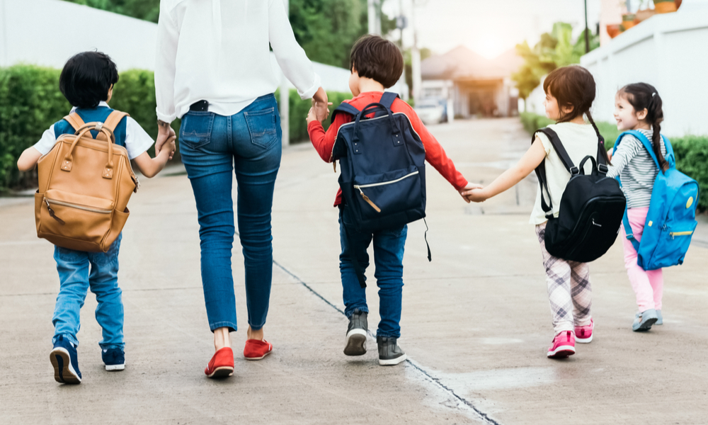 Mom walking four kids into daycare