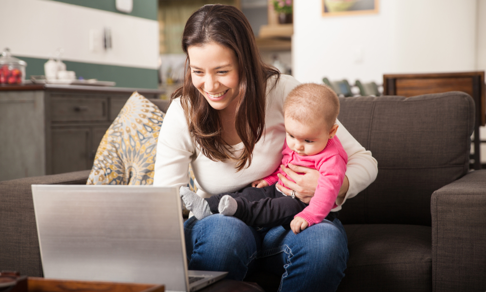Mom on laptop while holding infant