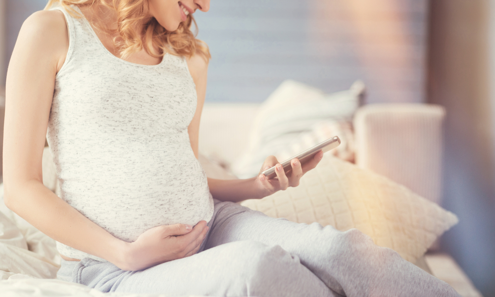 Pregnant mother using smartphone to research child care