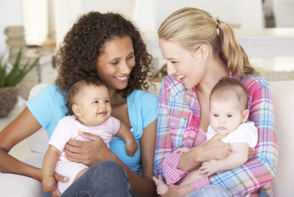 Two moms on couch with babies