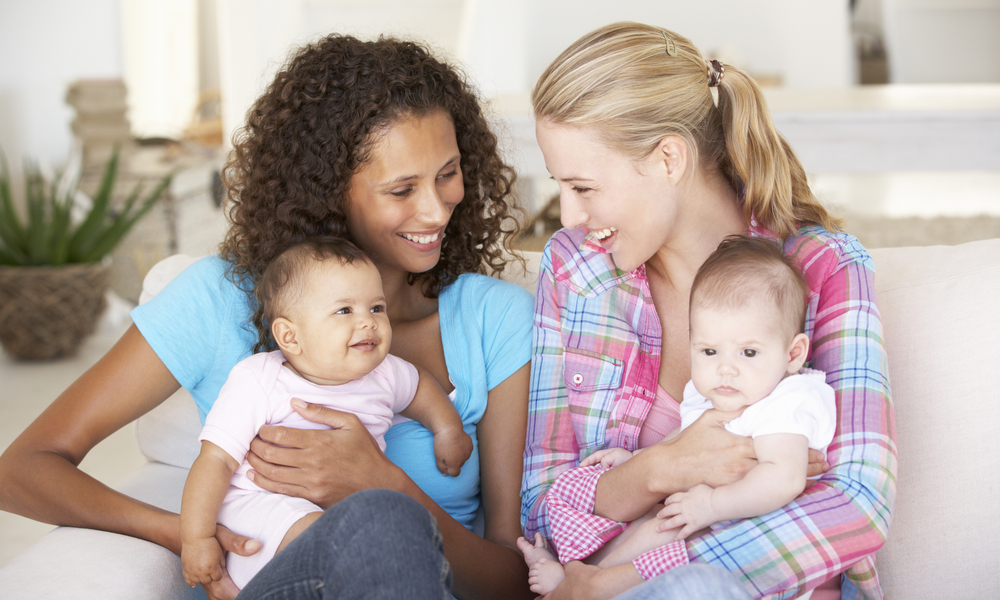 Two moms on couch with babies