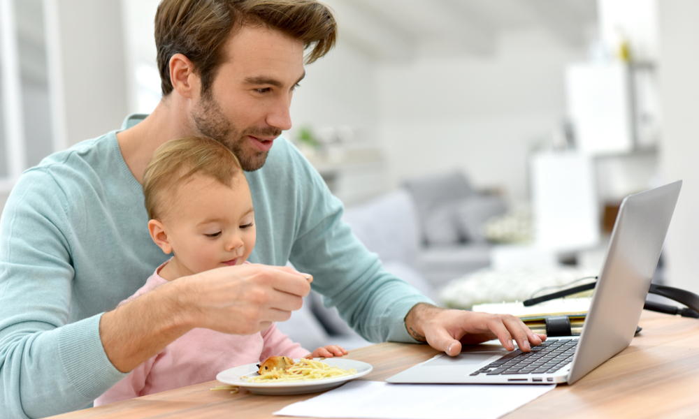 Dad on laptop with baby in lap