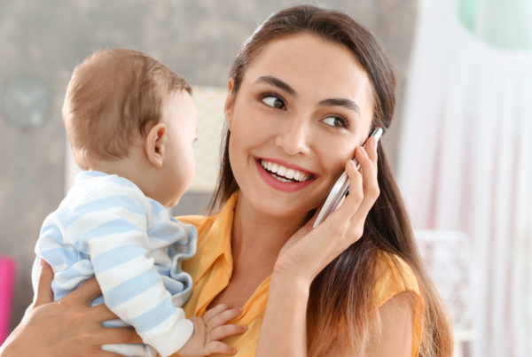 Mom on phone while holding baby