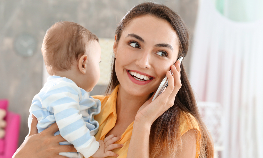 Mom on phone while holding baby