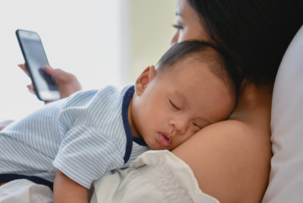 mom on phone with infant