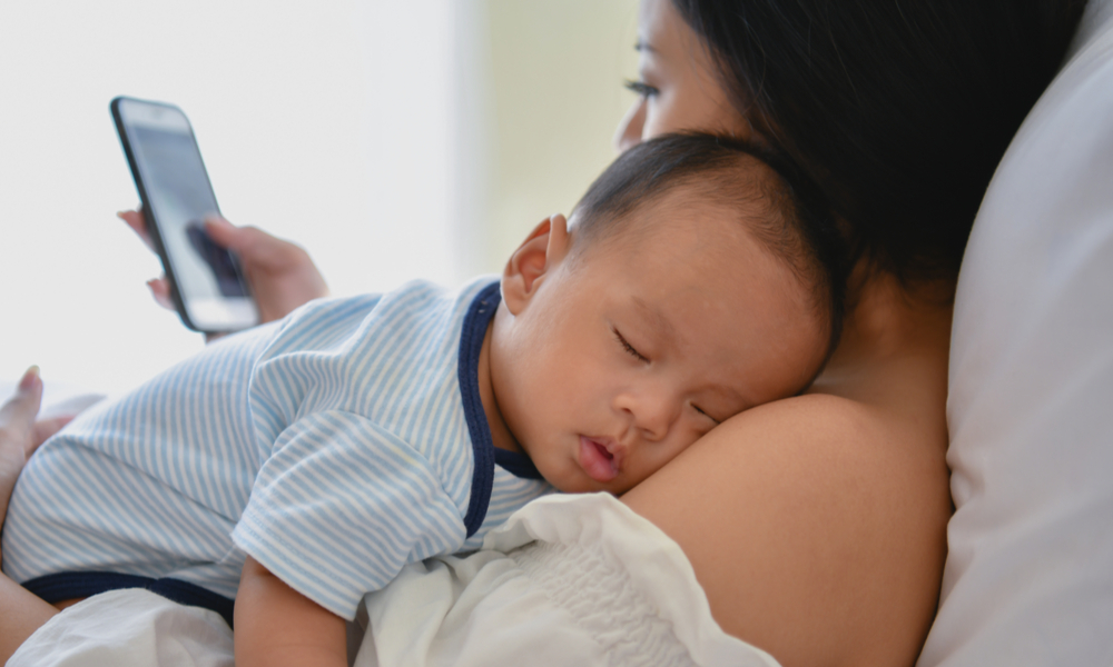 mom on phone with infant